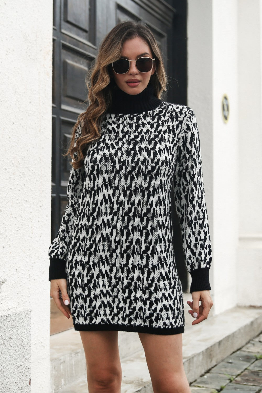 Black houndstooth knit turtleneck mini dress with long sleeves.