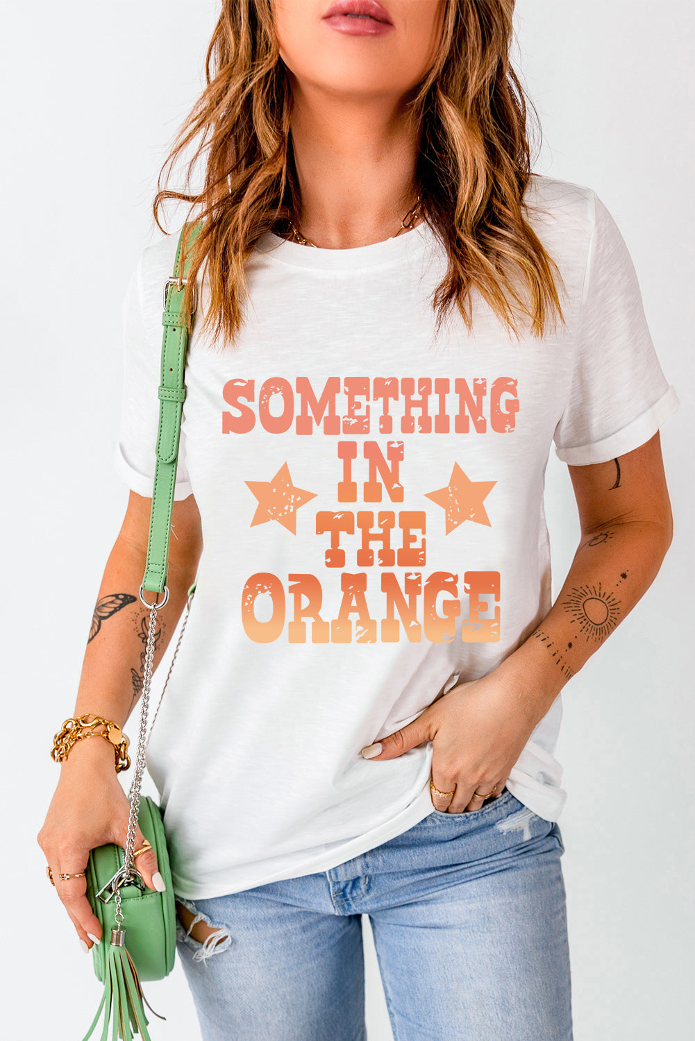 White graphic tee with faded orange text and stars, casual crew neck t-shirt.