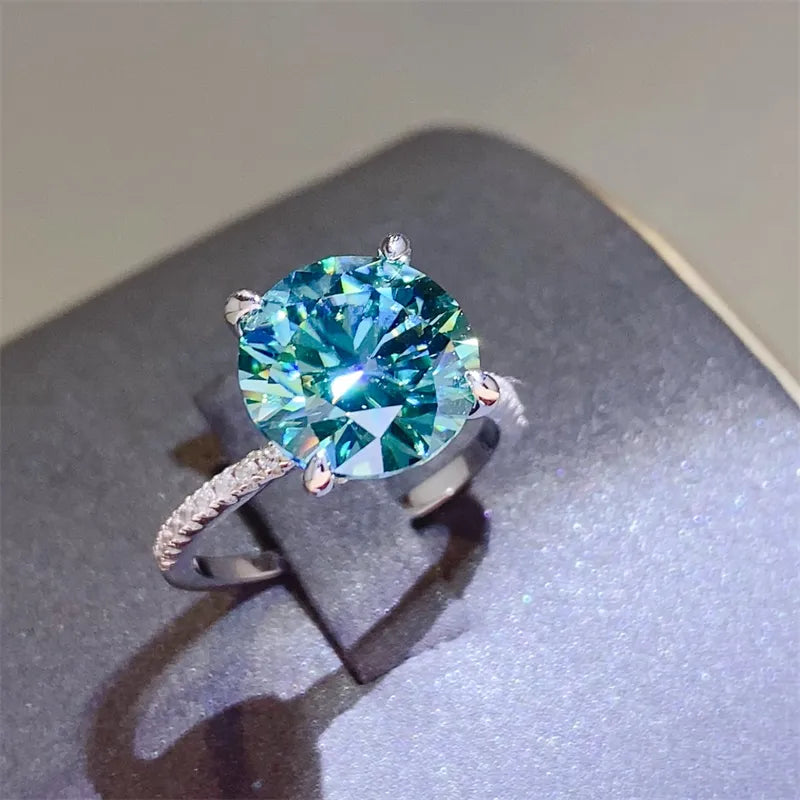 Radiant teal moissanite pavé ring in silver with a large round-cut center stone.