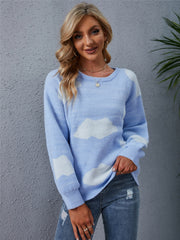Light blue acrylic sweater with white cloud intarsia pattern, crew neck, and long sleeves.