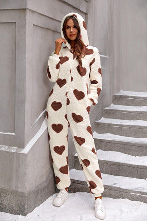 Heart-print sherpa onesie with hood in cream with brown hearts.