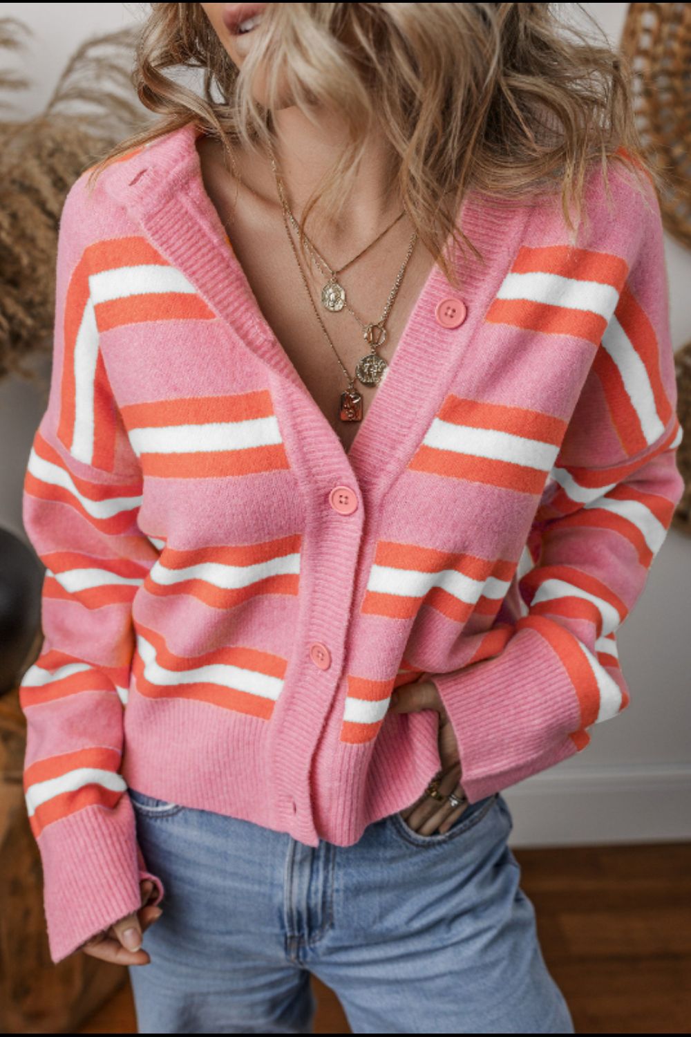 Pink striped knit cardigan with button front and ribbed cuffs.