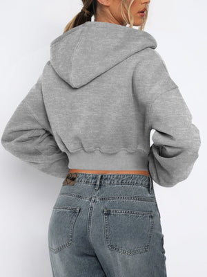 Gray cropped zip-up hoodie with ribbed hem and balloon sleeves.