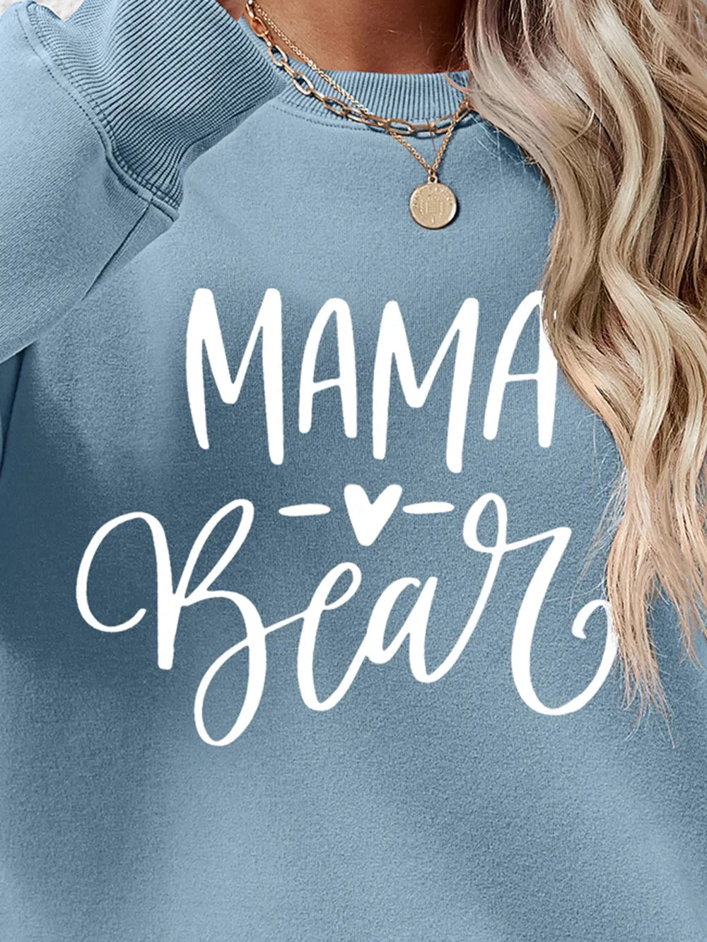 Light Blue Mama Bear graphic sweatshirt with crewneck, styled with a necklace.
