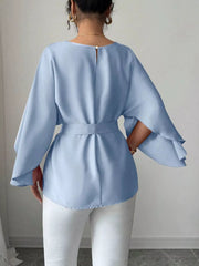 Light blue belted blouse with batwing sleeves and button back detail.