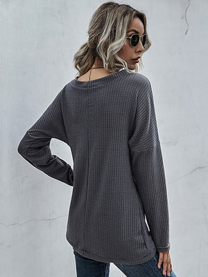 Dark gray waffle knit crossover blouse with long sleeves and a relaxed fit.