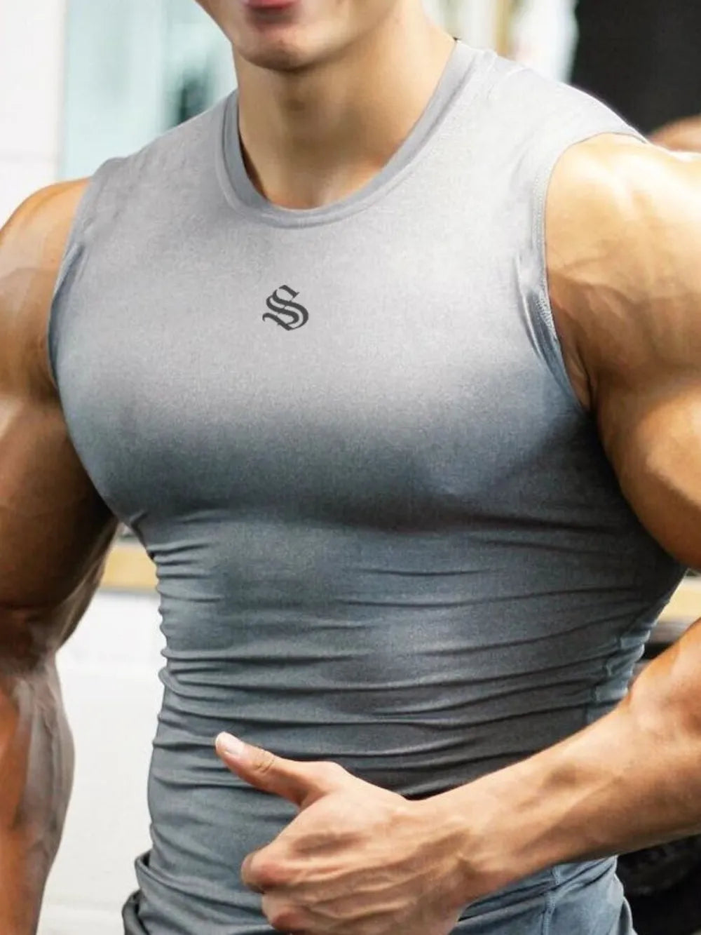 Performance Fit Muscle Tank in gray with a black logo, showing a close-up of the chest and arms.