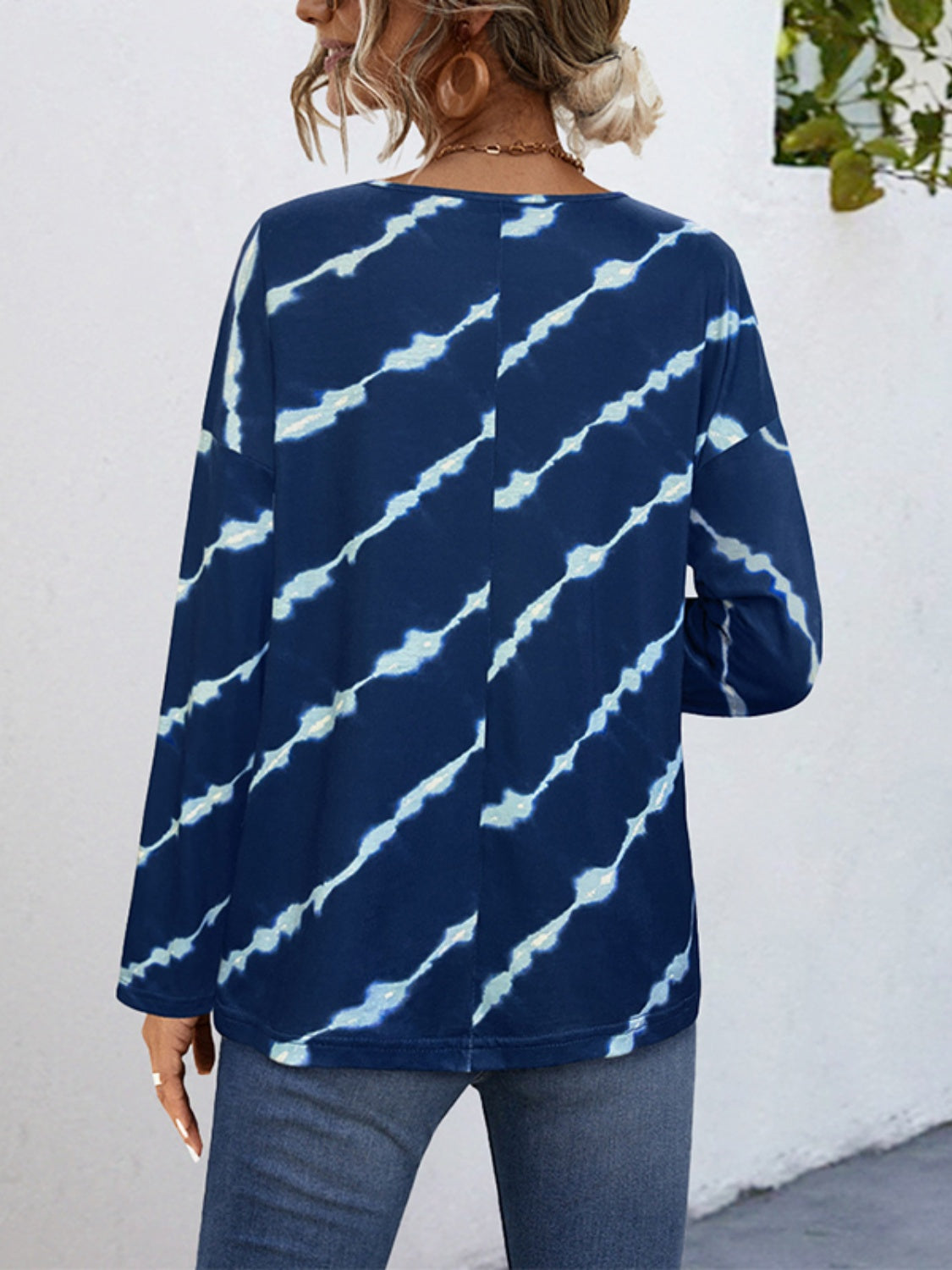 Indigo tie-dye long sleeve henley top in peacock blue with diagonal white streaks.