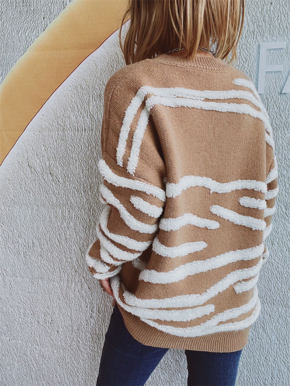 Tan knit crewneck sweater with textured white stripe pattern