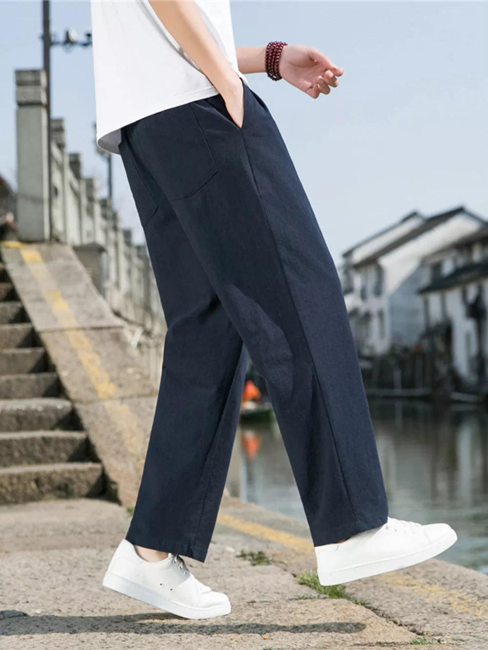 Men's navy blue sweatpants with drawstring and pockets, styled with a white t-shirt.