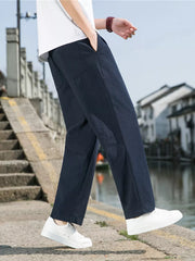Men's navy blue sweatpants with drawstring and pockets, styled with a white t-shirt.