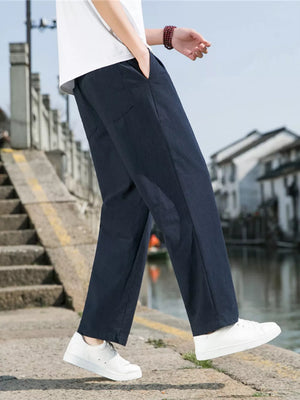 Men's navy blue sweatpants with drawstring and pockets, styled with a white t-shirt.