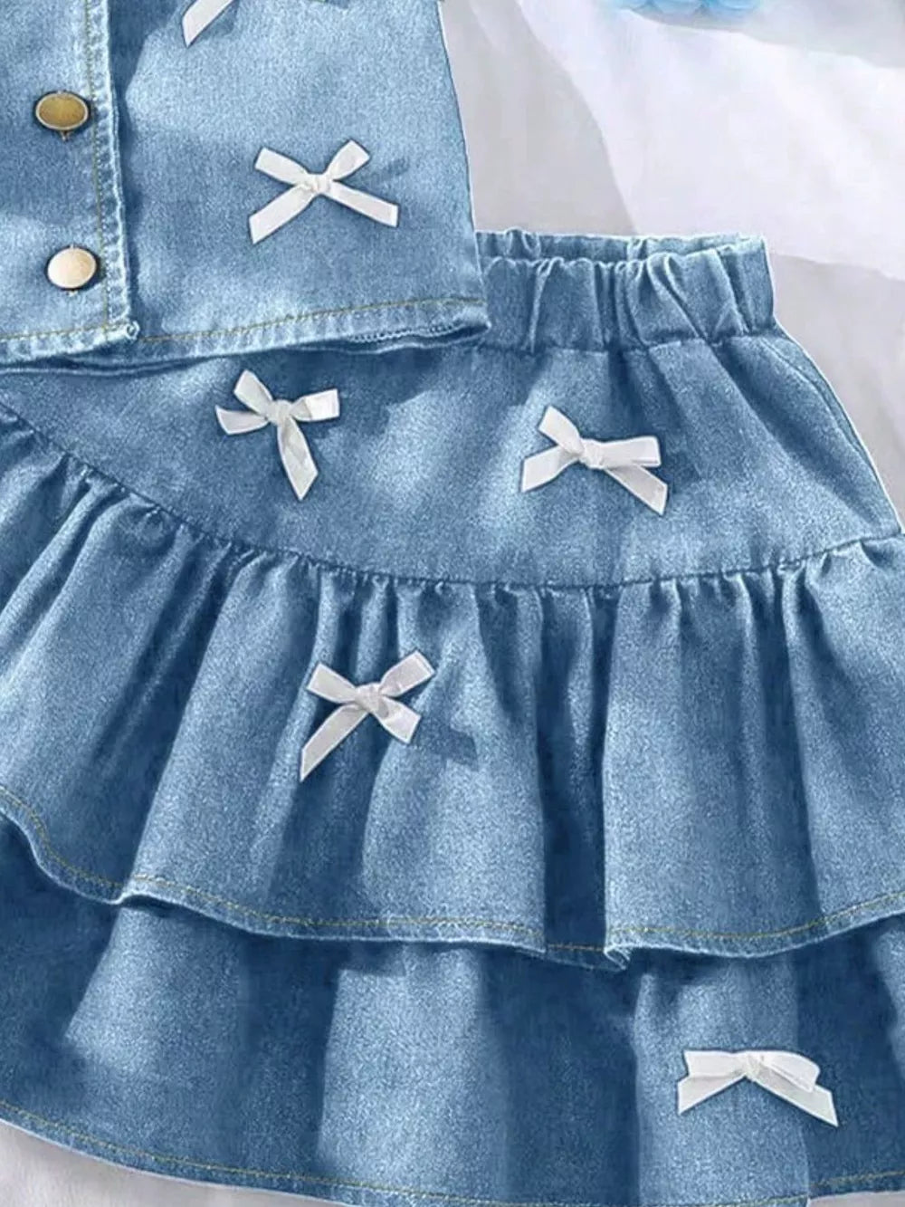 Light blue denim halter set with white bow accents and tiered skirt.