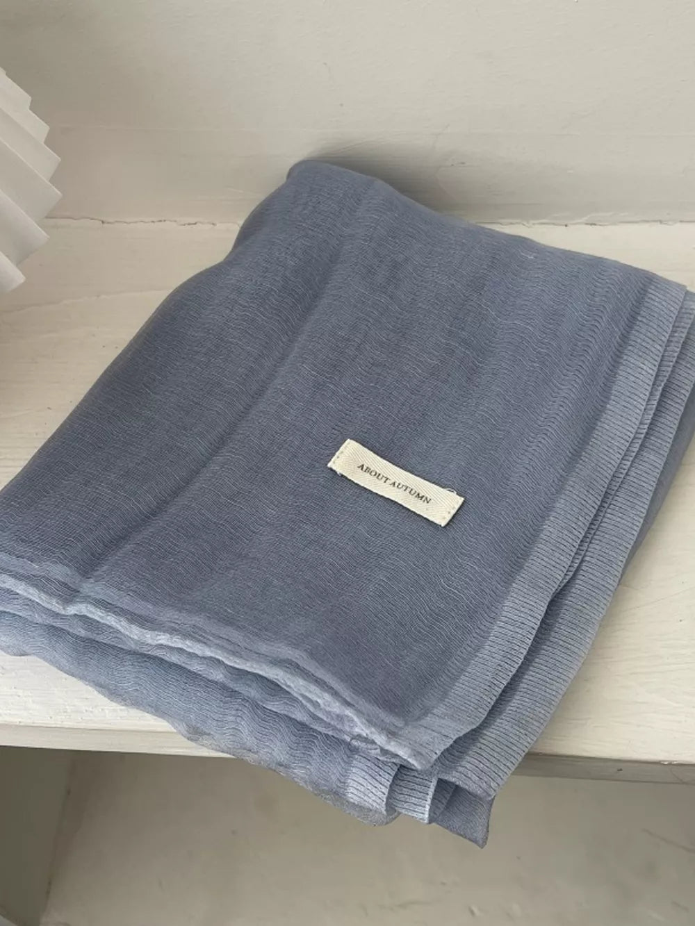 Light blue sheer polyester scarf with a delicate texture and a small white tag.