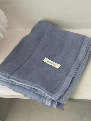Light blue sheer polyester scarf with a delicate texture and a small white tag.