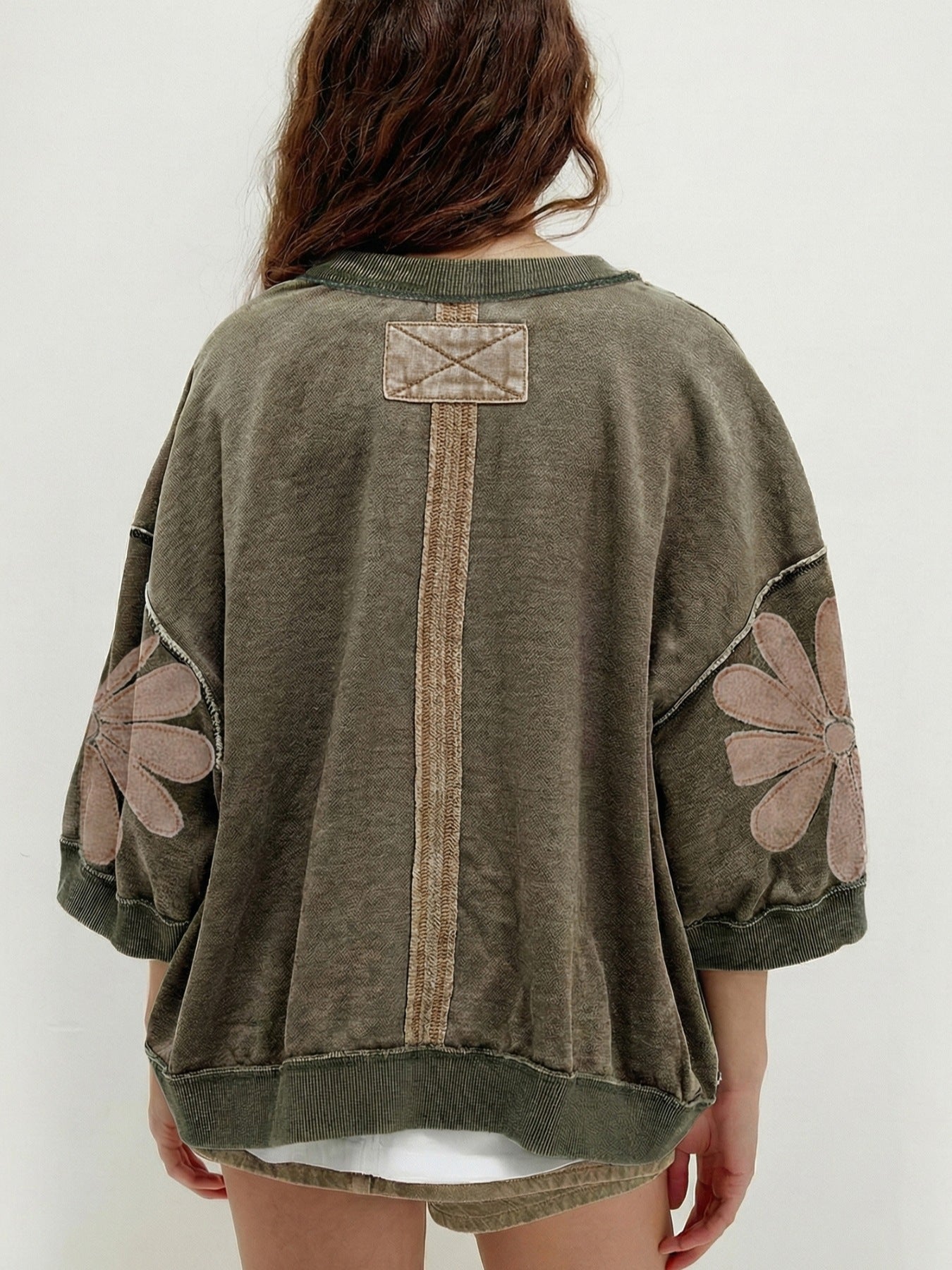 Mineral wash green cotton sweatshirt with flower patches on sleeves and back detail.