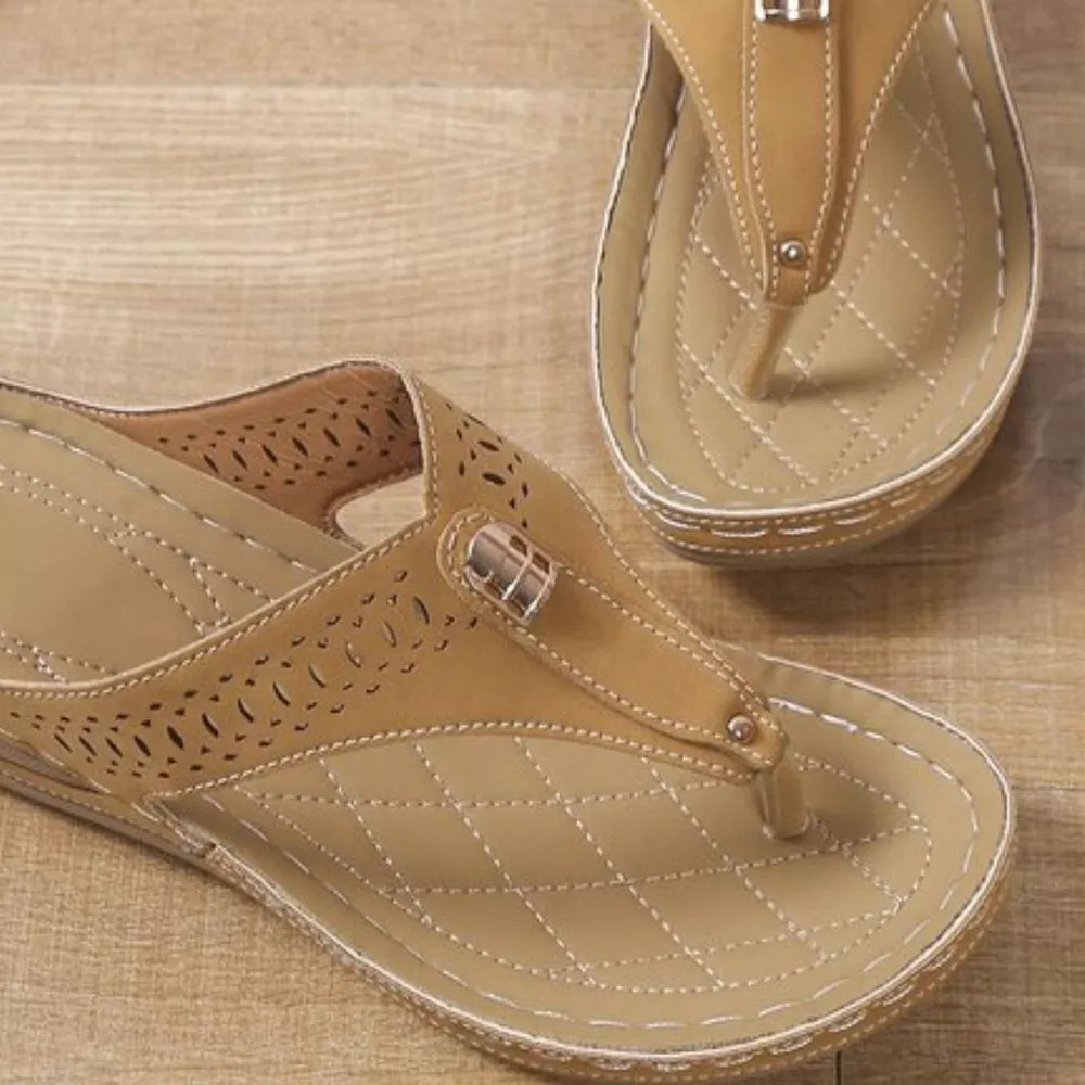 Khaki perforated leather wedge sandals with a quilted footbed and decorative buckle.