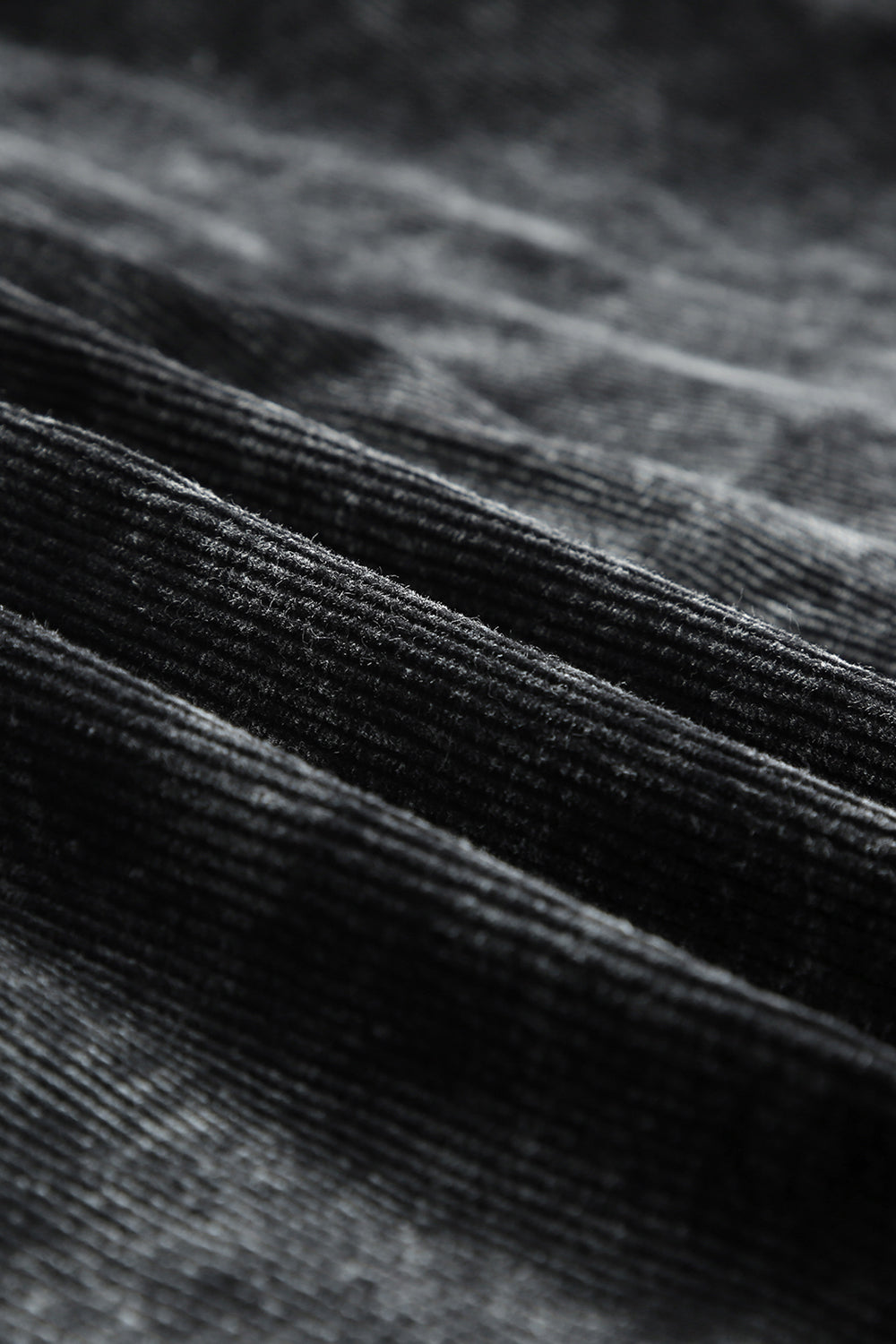 Textured corduroy overshirt in faded black with visible ridges and soft nap.