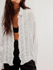 White linen button-down blouse with ruffled front detail