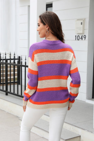Crewneck knit sweater with bold horizontal stripes in purple, orange, and cream.