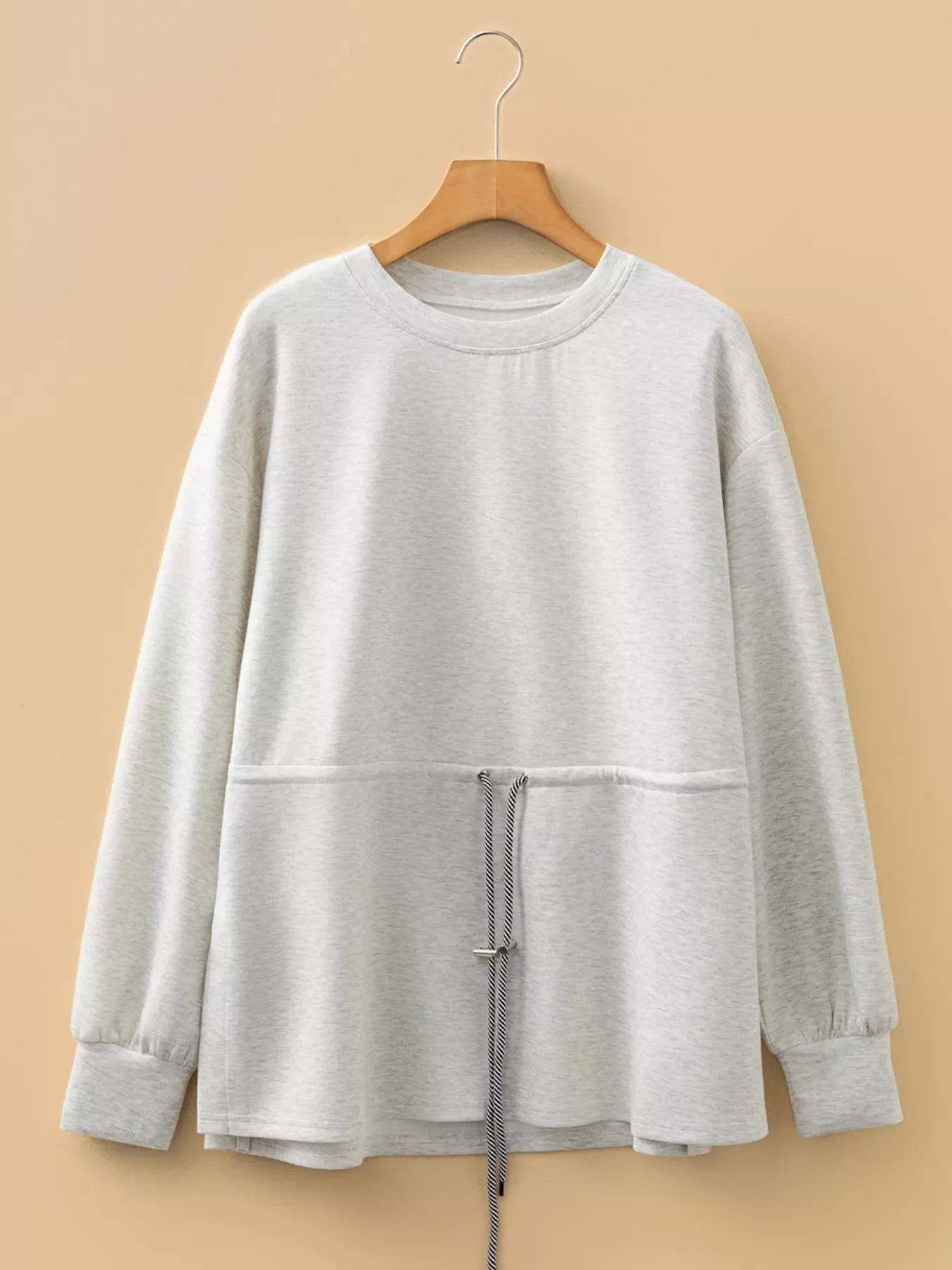 Light gray tunic sweatshirt with drawstring waist detail and crew neck.