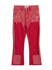 Split panel bootcut jeans in red with paint splatter detail and distressed patches.