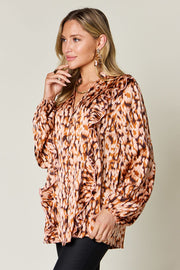 Caramel print ruffle front blouse with buttoned placket and balloon sleeves.