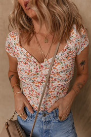 Floral print ruched bodysuit with sweetheart neckline and short sleeves.