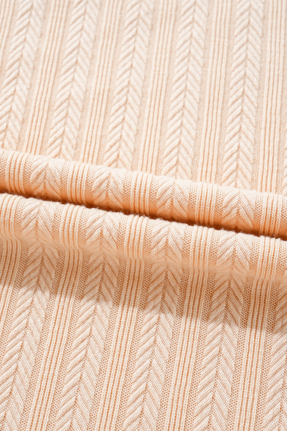 Textured ribbed sleeveless collar jumpsuit in eggshell with a chevron pattern.