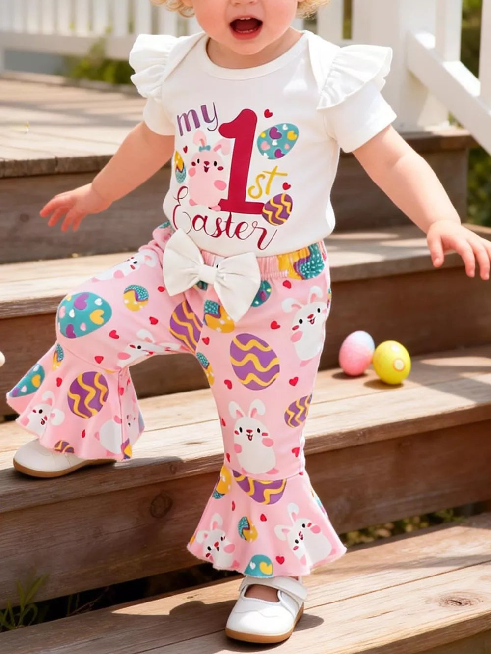 Baby Easter outfit with white ruffled sleeve top and pink bunny & egg print bell bottoms.