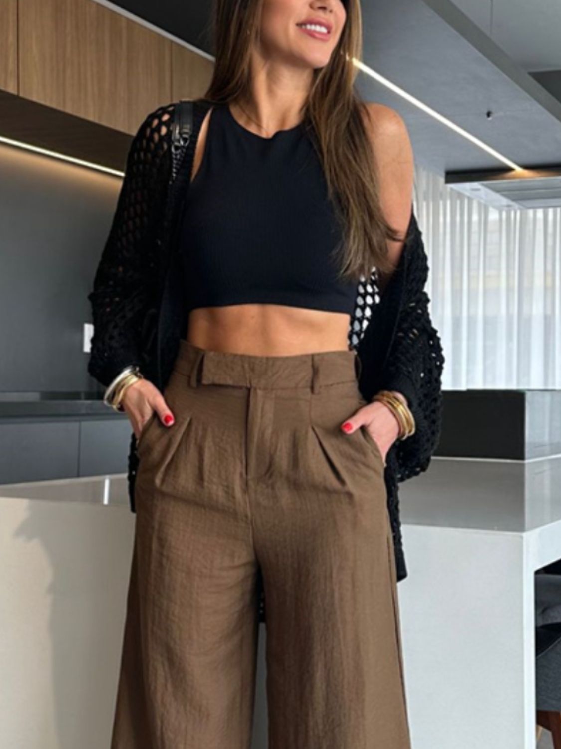 Black open-knit crochet cardigan shrug with a relaxed fit, worn over a black crop top.