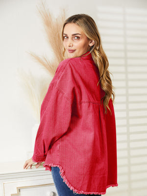 Distressed denim overshirt in orange-red with raw hem and buttoned front.