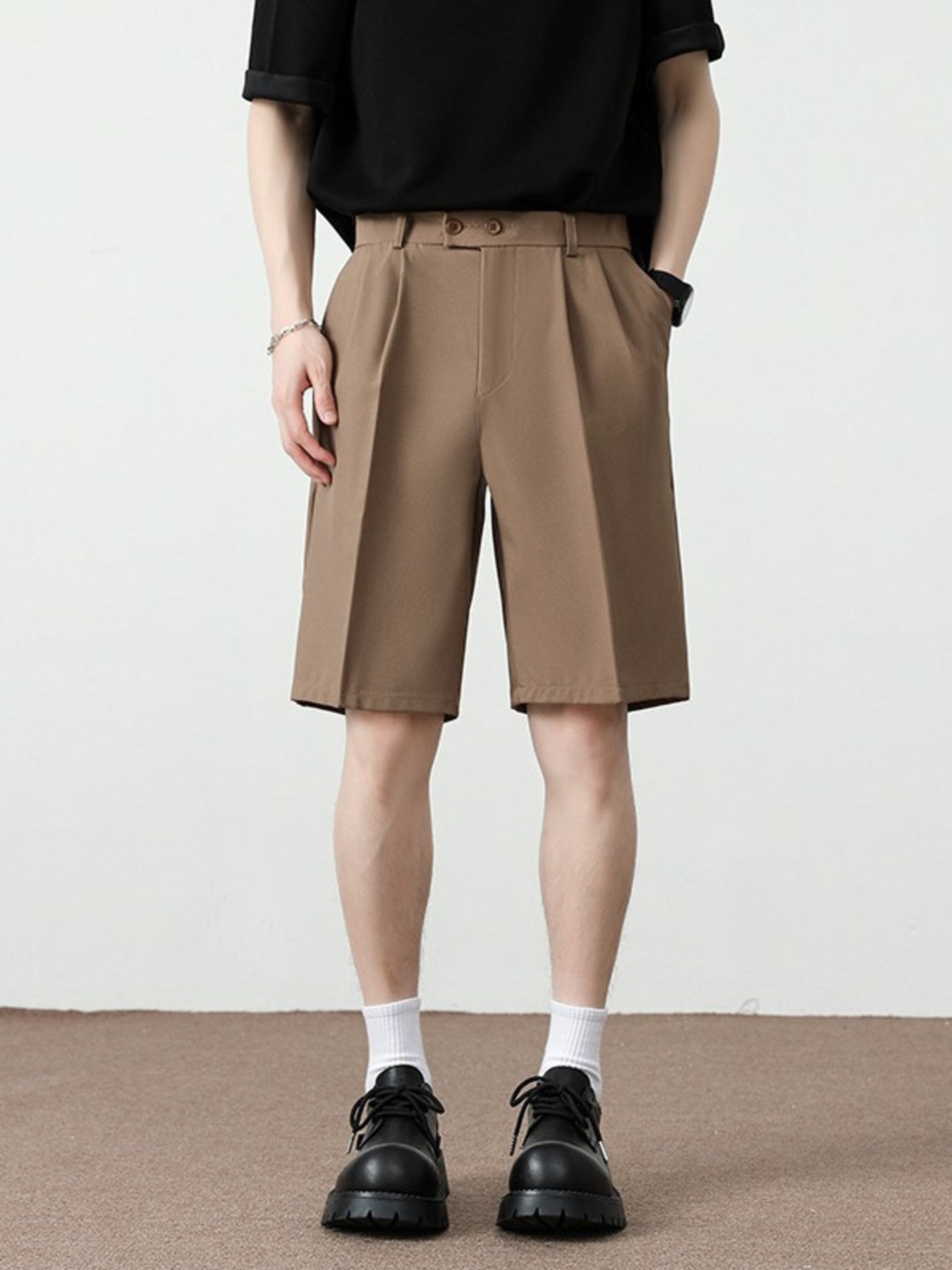 Men's light brown pleated detail loose-fit chino shorts with a relaxed cut.