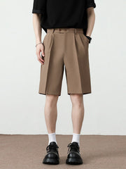 Men's light brown pleated detail loose-fit chino shorts with a relaxed cut.