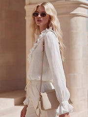 White ruffled V-neck maternity shirt with long sleeves and elastic cuffs.