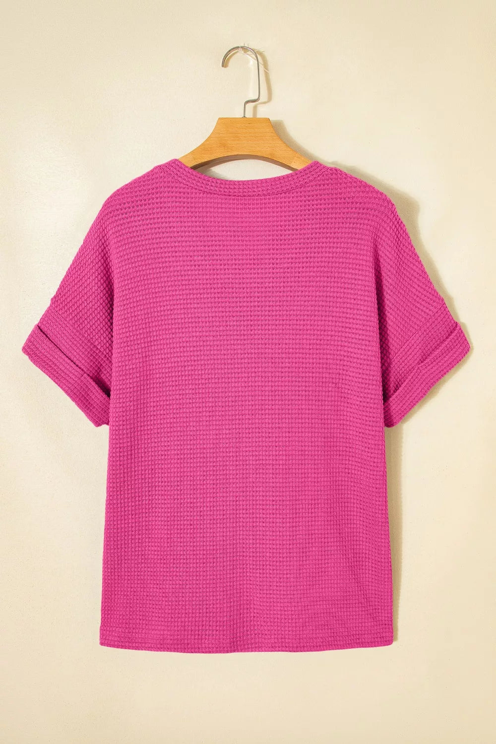 Hot pink waffle knit V-neck t-shirt with cuffed short sleeves.