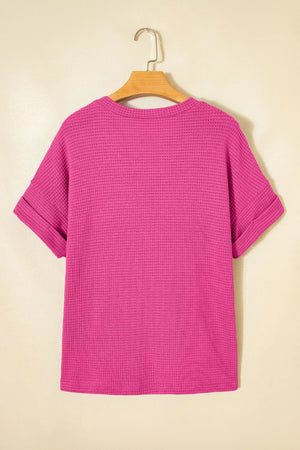 Hot pink waffle knit V-neck t-shirt with cuffed short sleeves.
