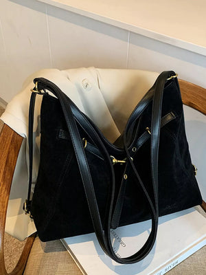 Black slouchy crossbody bag with gold hardware and adjustable strap.
