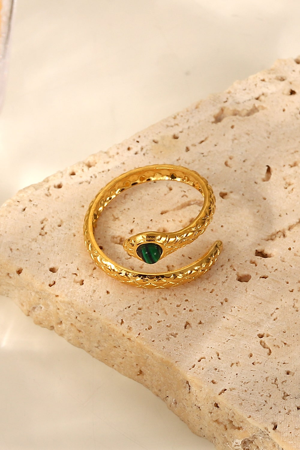 Gold serpentine ring with malachite accent, featuring a detailed coil design.