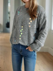 Gray knit sweater with geometric sequin embellishments and a crew neck.