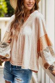 Dust Storm blouse with gathered V-neck and patchwork sleeves featuring polka dots and tropical leaves.
