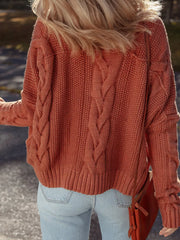 Chunky oversized cable-knit sweater in rust orange with ribbed cuffs and hem.