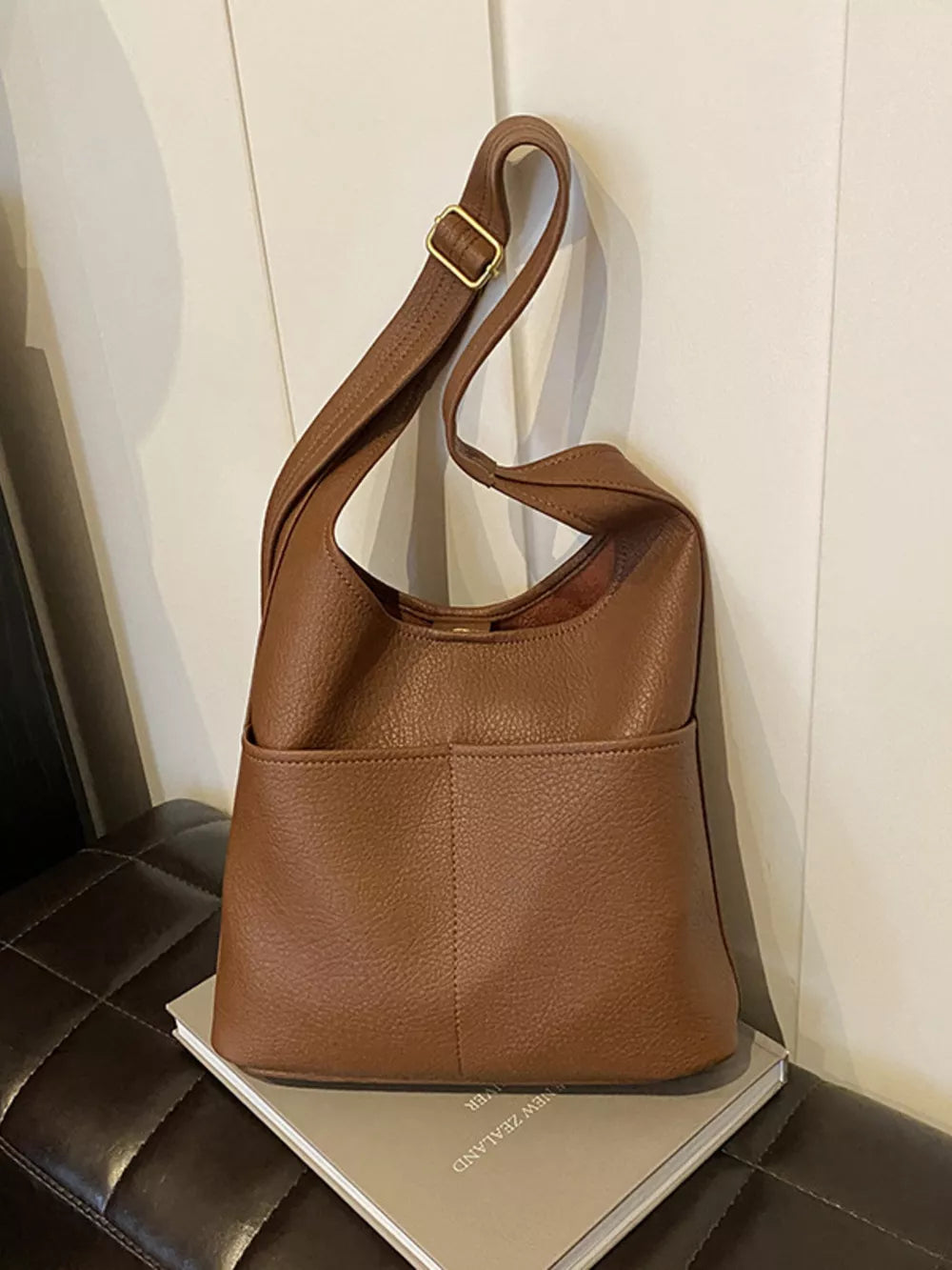 Brown textured pu leather shoulder bag with adjustable strap and front pockets