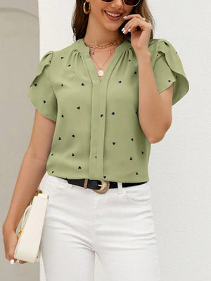 Matcha green blouse with black hearts, puff sleeves, and V-neck.