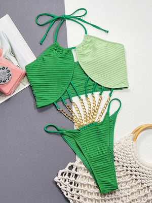 Textured green halter swimsuit with gold chain detail and contrast light green panels.