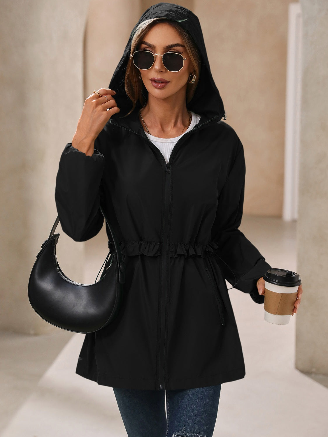 Black hooded performance jacket with ruffled drawstring waist and zip front.