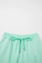 Mint green drawstring lounge shorts with elastic waistband and pockets.