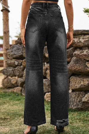 Distressed wide-leg denim trousers in dark wash with frayed hem and subtle whiskering.