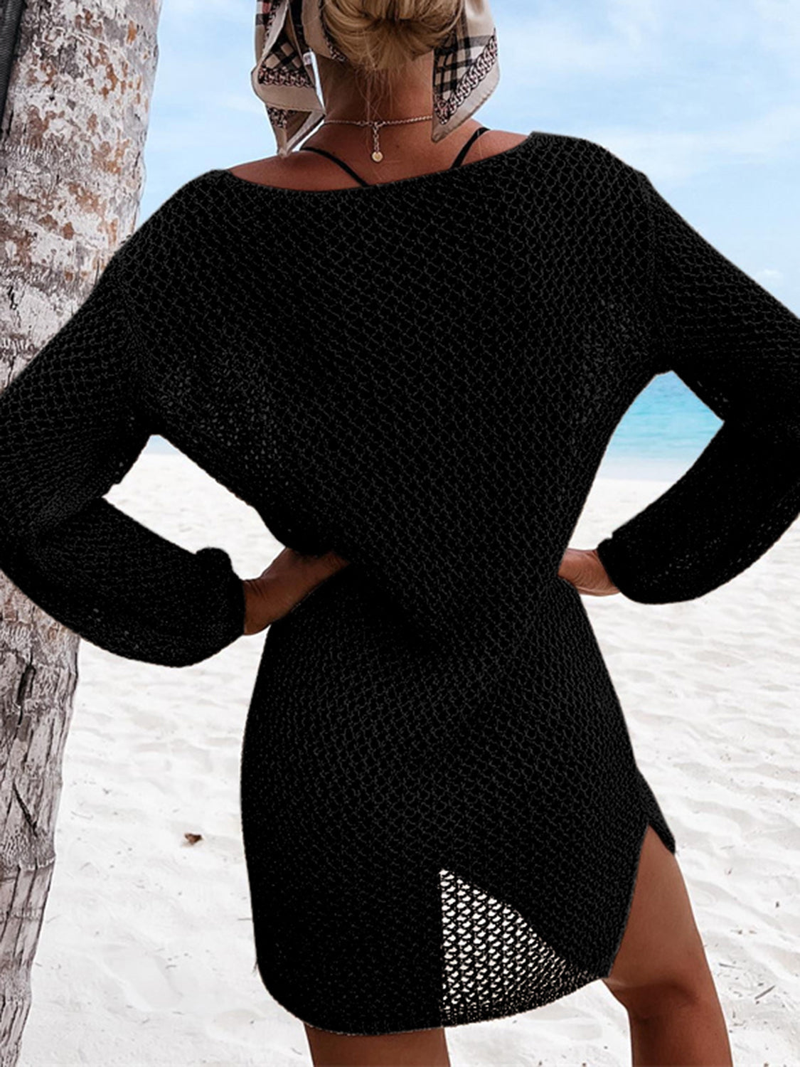 Black open-knit beach dress with long sleeves and side slit detail.