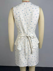 Floral peplum set in white with blue flowers, featuring a tie waist and ruffled hem.